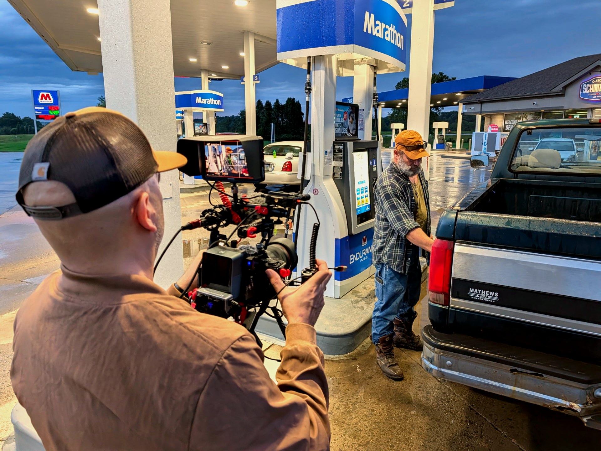 Camera operator framing a scene at a Marathon gas station during The Crossing shoot